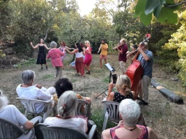 Un groupe de personnes en extérieur en train de danser devant un public