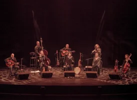 Un groupe de personnes en arc de cercle en train de jouer des instruments